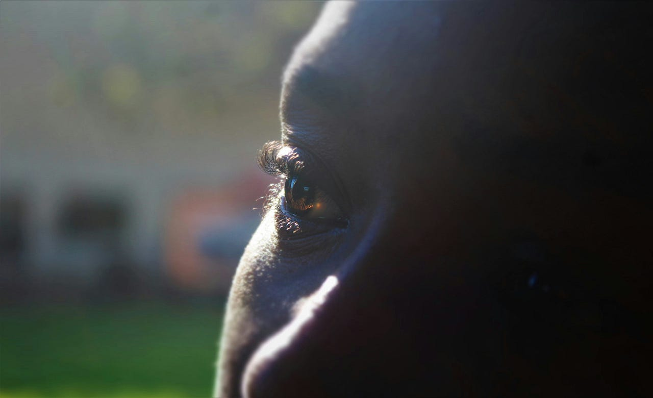 A person of color staring out