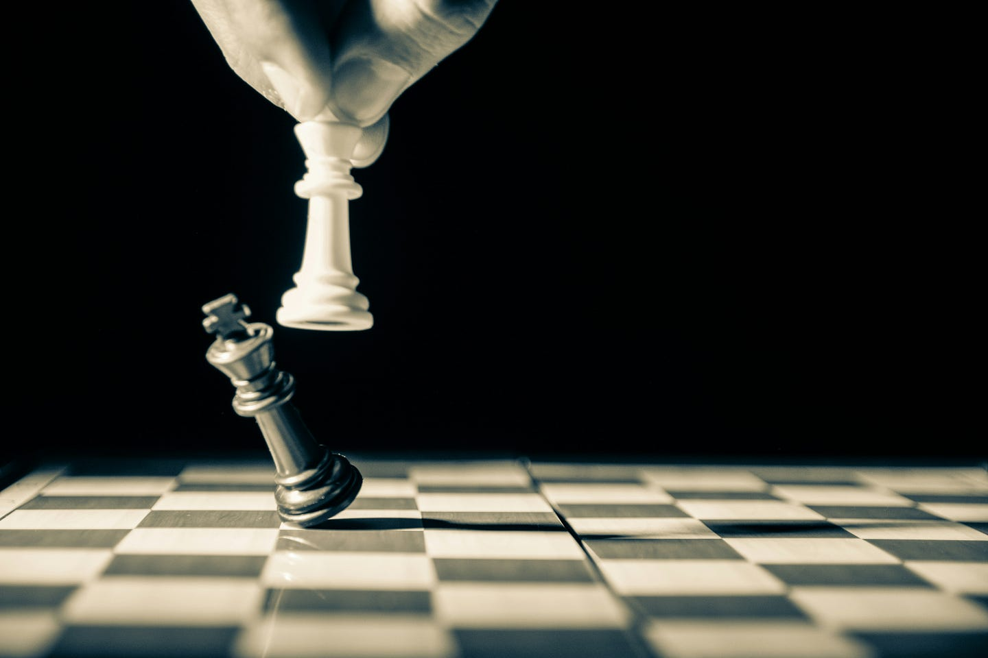 Image of person knocking opponent's chess piece.